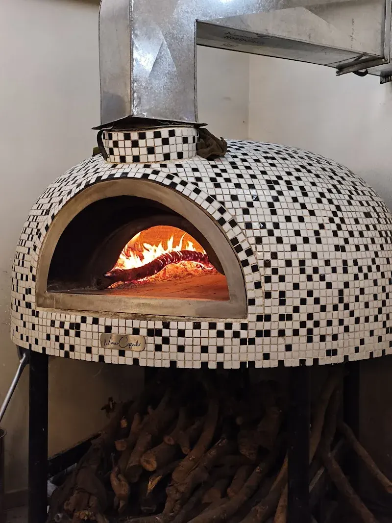 The black-and-white mosaic woodfired dome oven at Pizzeria da PS, fire burning inside